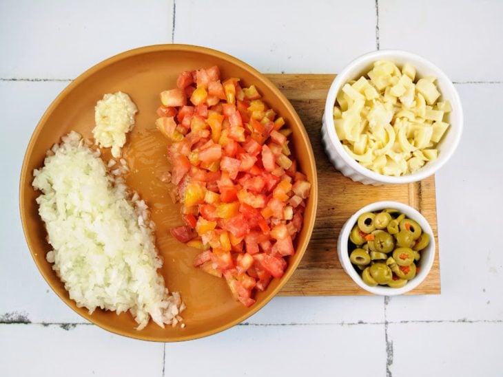 prato com cebola picada, tomate picado, mussarela ralada e azeitonas picadas