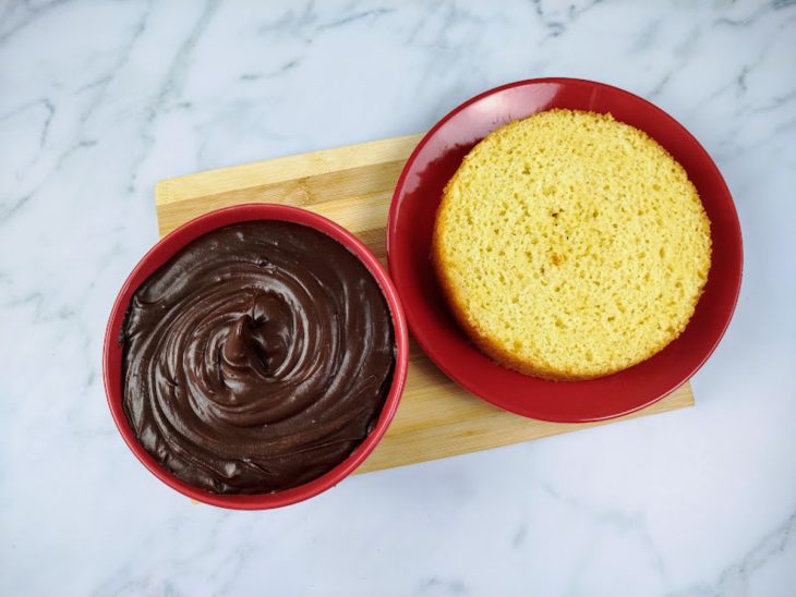 Uma camada de bolo e uma tigela com ganache de Nutella.