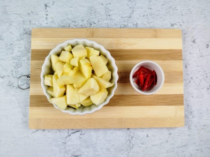 Maçã e pimenta fatiadas em recipientes.