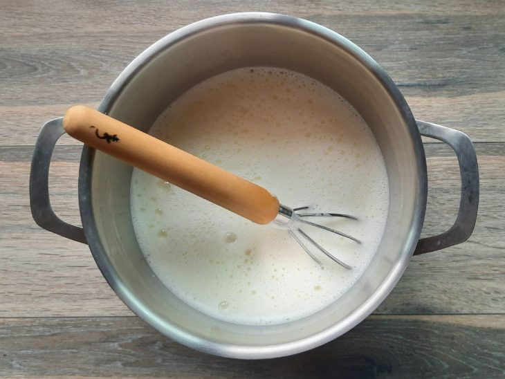 Panela com leite quente e gemas açucaradas.