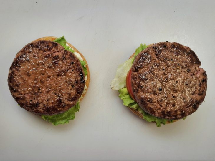 Hambúrgueres montados com salada nos pães.