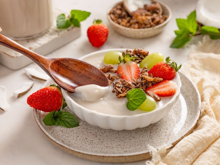 bowl com iogurte de coco vegano caseiro, morango, uva-verde e nozes.