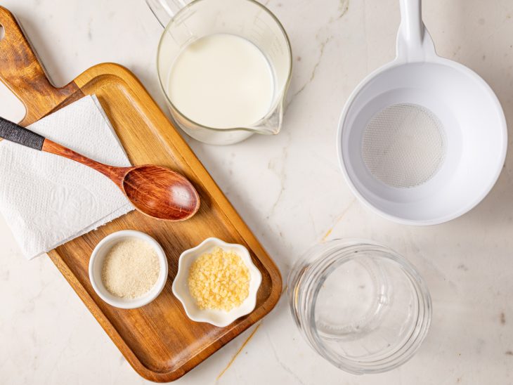 Ingredientes para o preparo do iogurte de kefir dispostos em uma mesa.