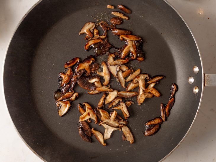 Frigideira com tirinhas de shitake refogando.