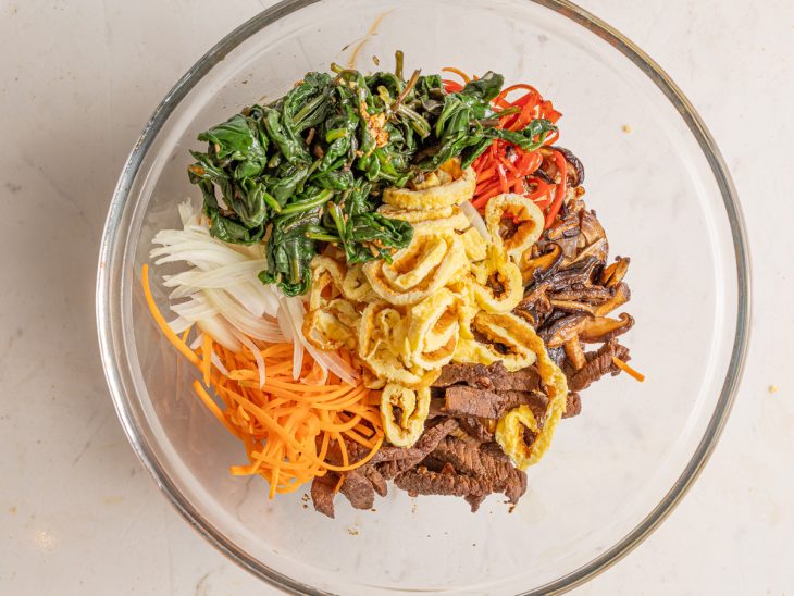 Uma tigela com todos os ingredientes do japchae.