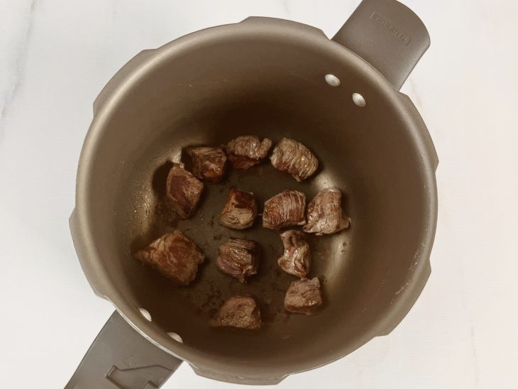 cubos de carne grelhados na panela de pressão