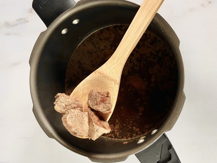 cubos de carne cozinhando na panela de pressão