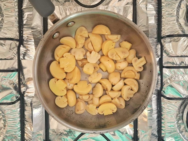 Uma frigideira com champignon e temperos.