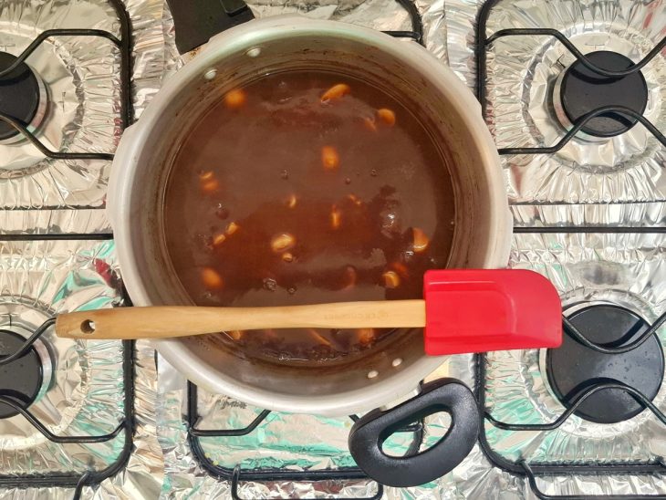 Uma panela de pressão com o caldo da carne, o vinho, o roux e o champignon.