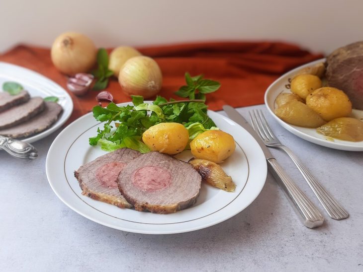 Lagarto em cortes acompanhado de batata, cebola e verduras e um prato