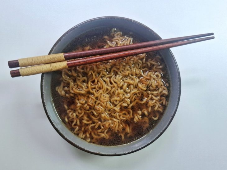 Tigela com macarrão, mistura de shoyu com alho e água quente.