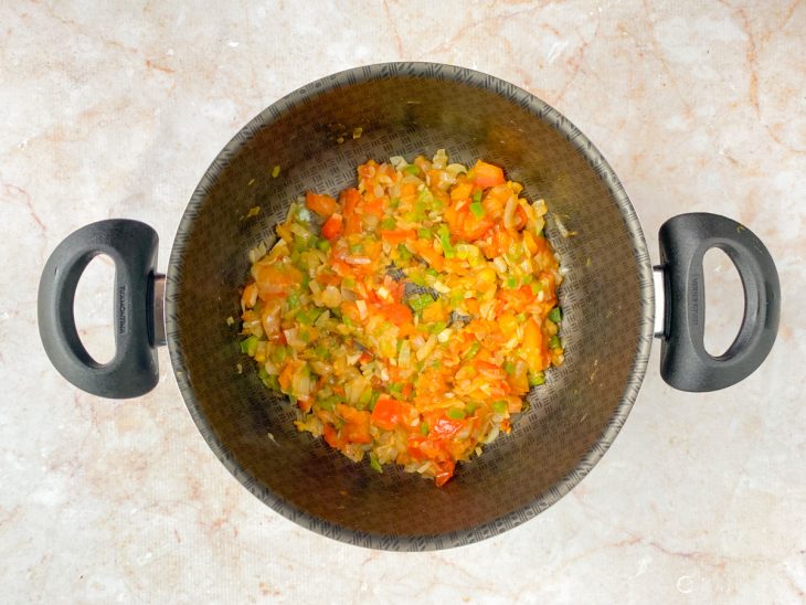 Cebola, alho, pimentão e tomate picados em uma panela com azeite.