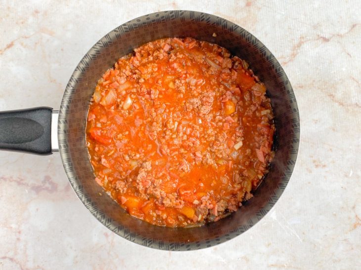 Tempero, alho e passata de tomate, adicionados na panela.