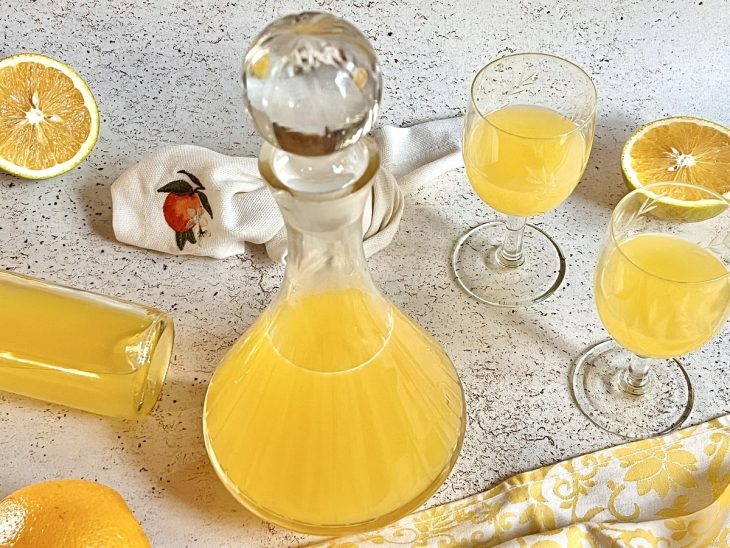 Uma jarra e taças contendo licor de laranja.
