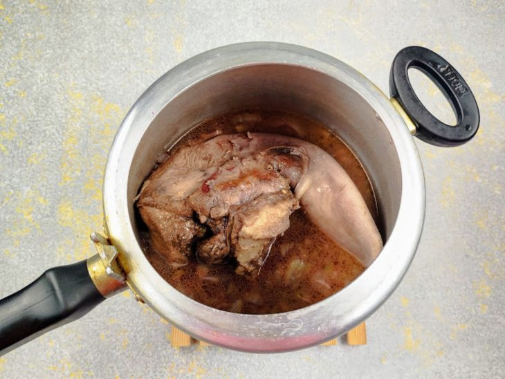 Uma panela de pressão com a língua bovina e o molho.