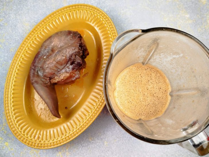 Um prato com a língua bovina após cozimento e um liquidificador com o caldo.