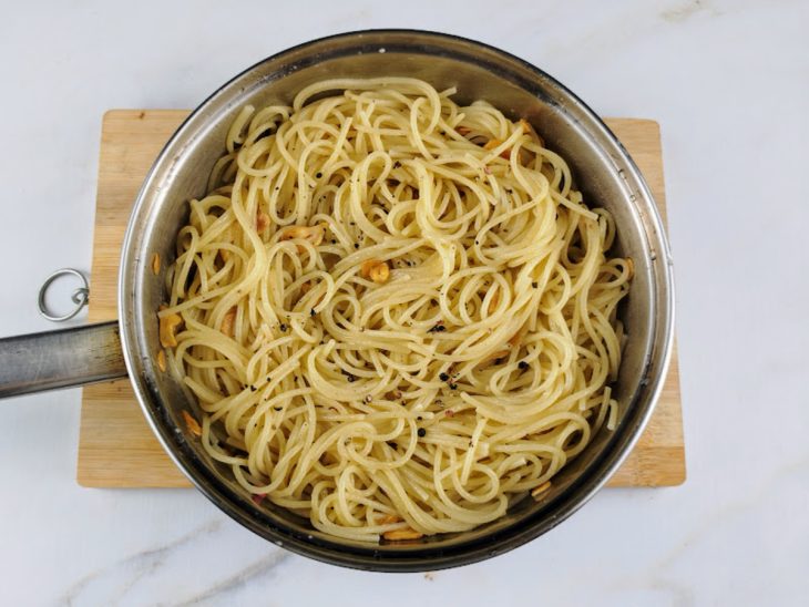 Macarrão adicionado na frigideira e incorporado ao alho.