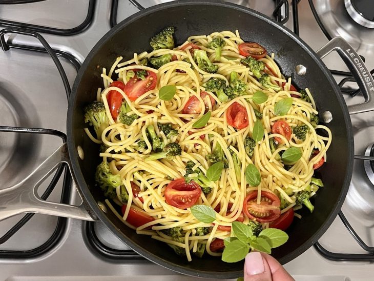 Uma panela com a mistura do macarrão e os vegetais.