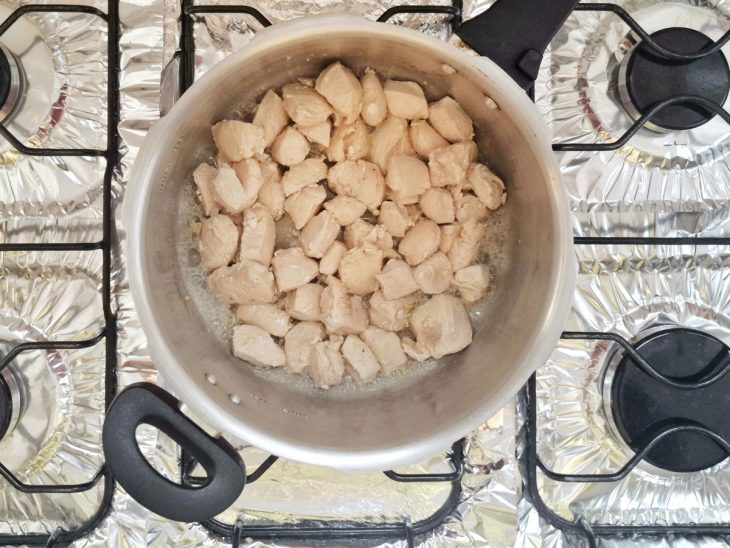 Frango em cubos na panela temperado com sal e pimenta-do-reino.