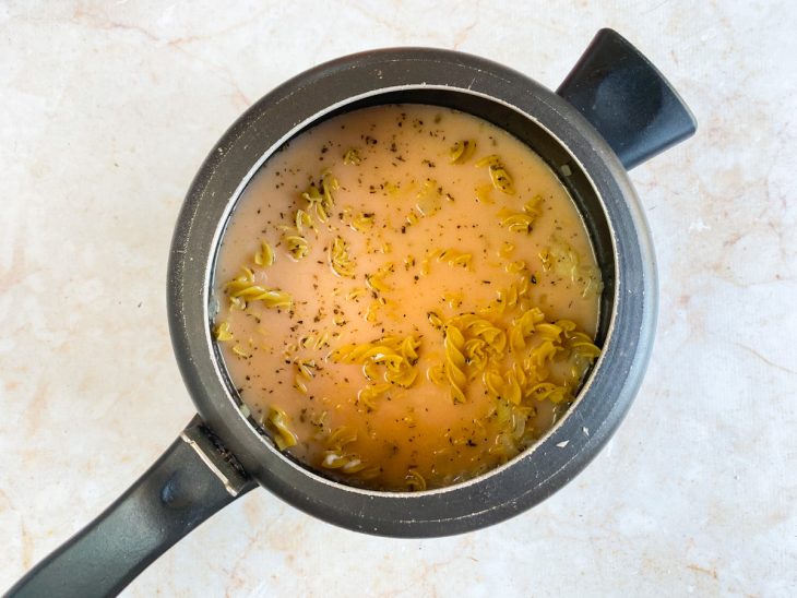 Creme de leite, macarrão e água adicionados na panela.