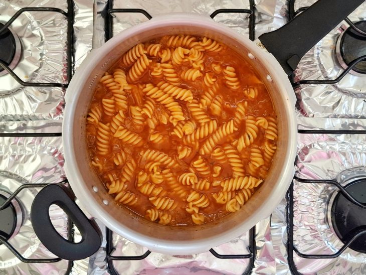 Macarrão e água adicionados e uma panela.