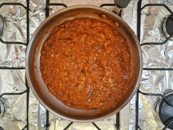 Molho de tomate, temperos e sardinha adicionados na frigideira.