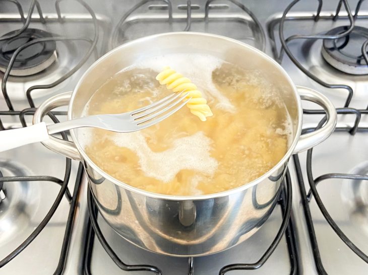 Macarrão al dente em uma panela com água.