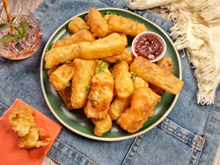 Um prato contendo mandioca com queijo na air fryer.