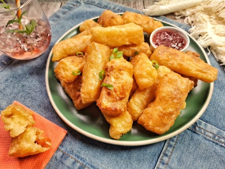 Um prato contendo mandioca com queijo na air fryer.