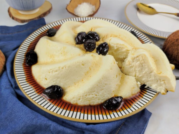 Manjar de coco com creme de leite finalizado com calda de ameixas, pronto para servir.