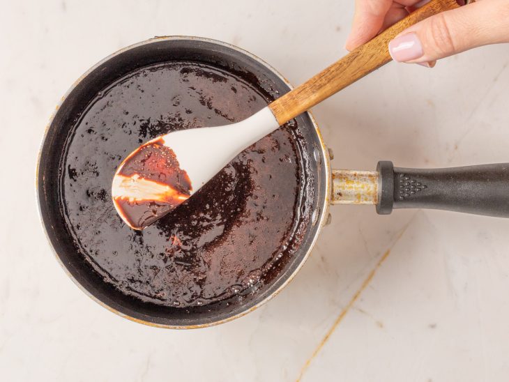 Calda de chocolate em uma panela com espátula mostrando o ponto napê.