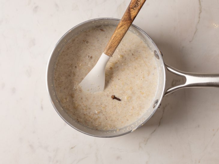 Uma panela com a mistura dos ingredientes e uma espátula.