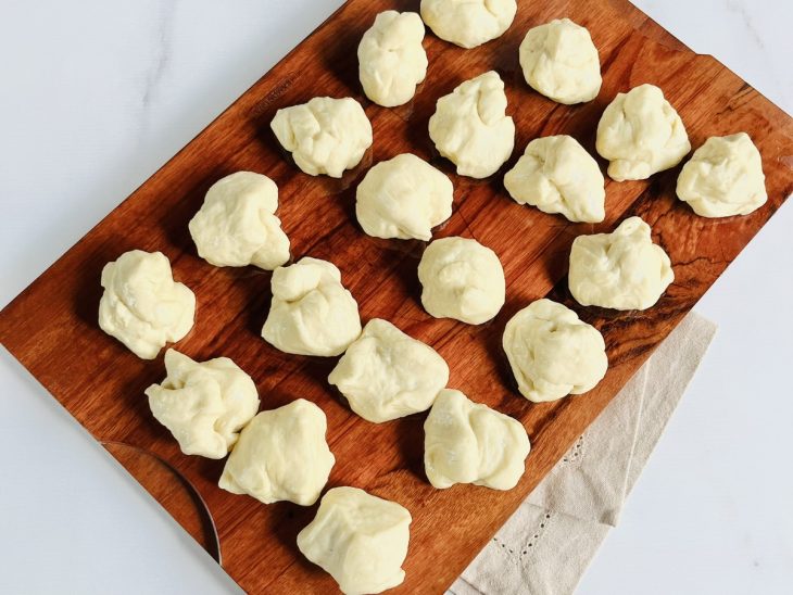 Uma tábua com porções da massa de pão.