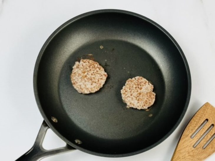 Hambúrgueres fritando em frigideira.