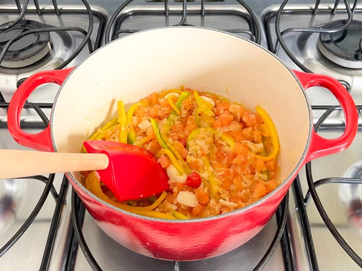 Pimenta-biquinho, pimentão e tomate adicionados na panela.