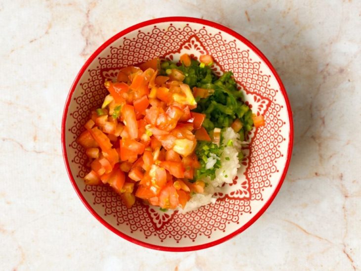 Cebola, salsinha, pimentão e tomate em uma tigela média.