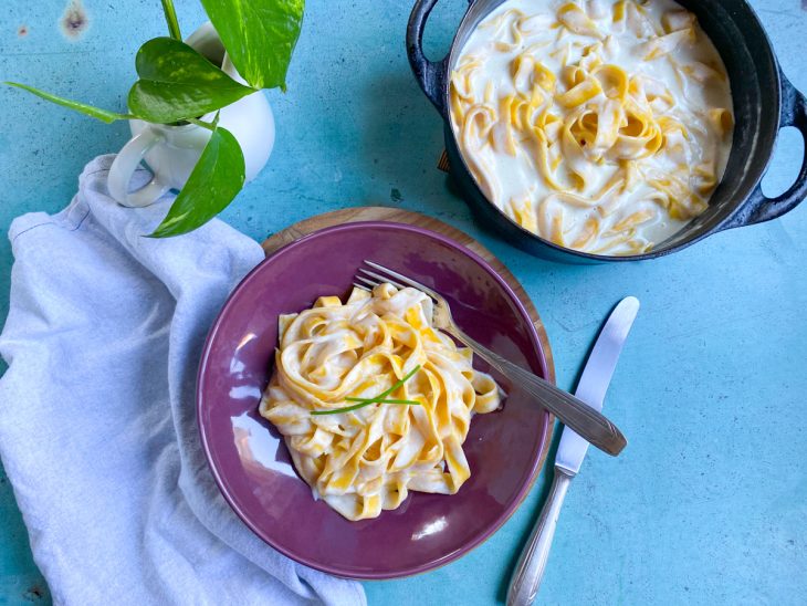 Um prato e panela contendo molho alfredo com cream cheese.