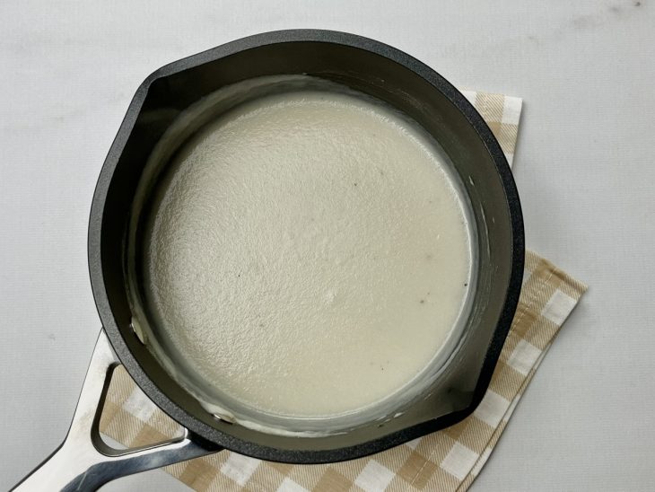 Uma panela com o molho branco light temperado.