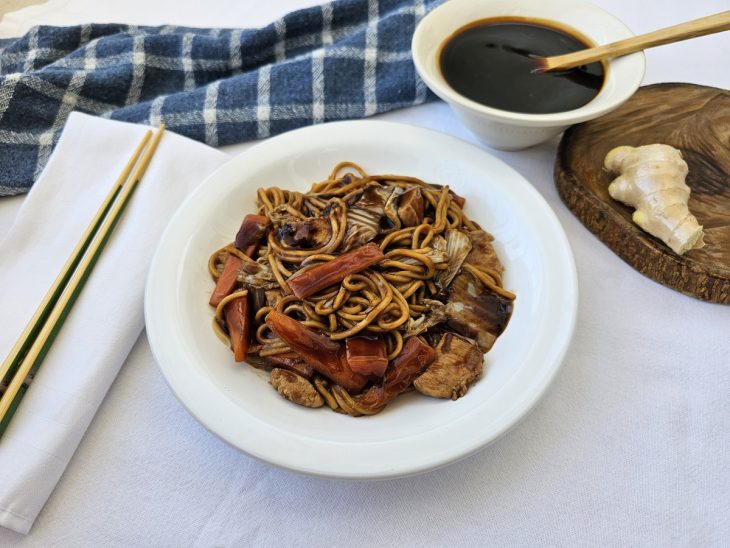 Um prato contendo yakisoba e molho.