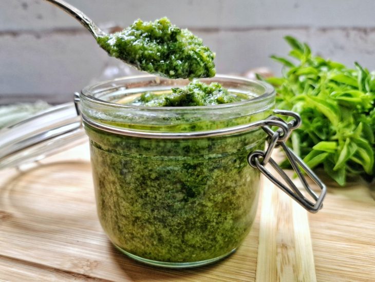 Molho pesto pronto para consumo em um pequeno pote de vidro.