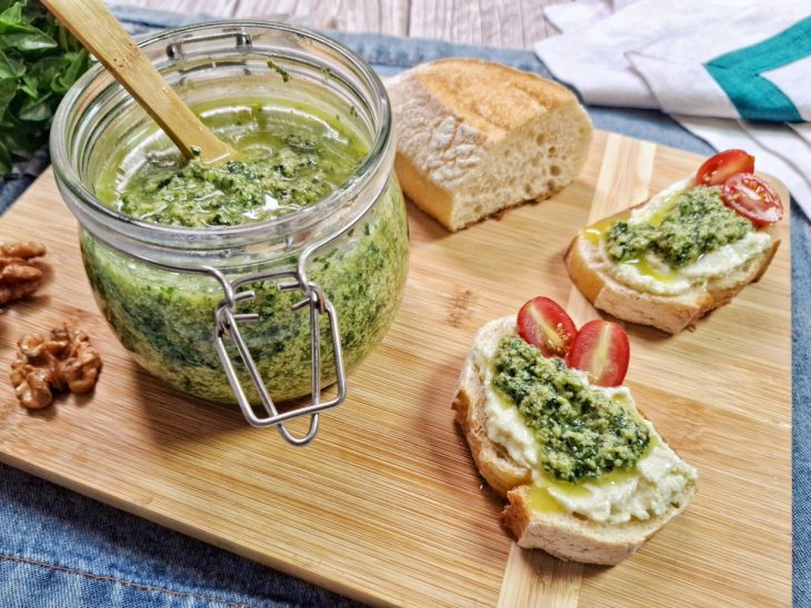 Molho pesto pronto para consumo combinado com pães e tomates.