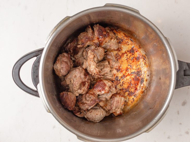 Uma panela com pedaços da carne e azeite.