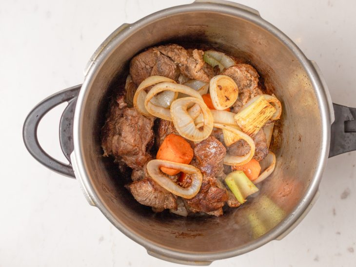 Uma panela com a carne e o mirepoix refogando.