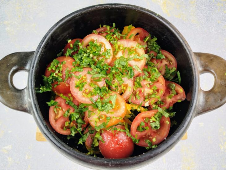 Panela com azeite, cebola, os pimentões, coentro e tomate.