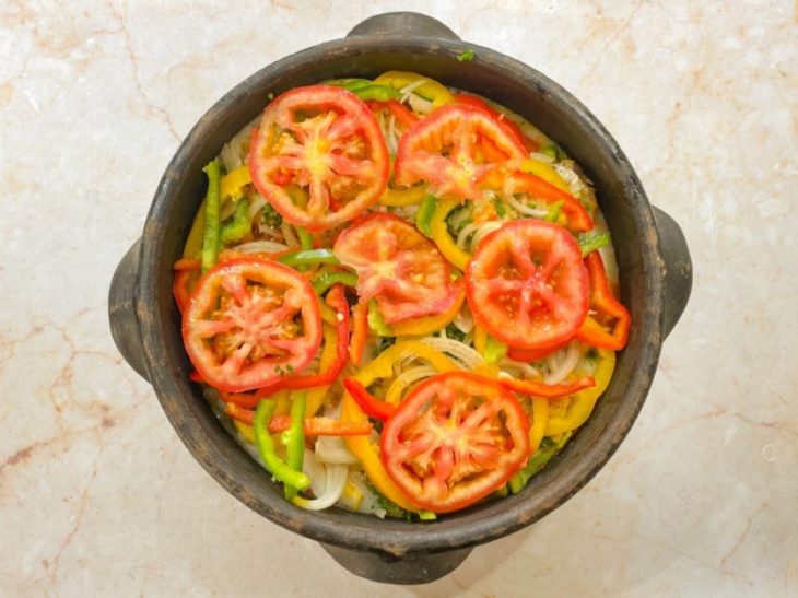 Cebola, pimentão e tomate acomodados na panela.