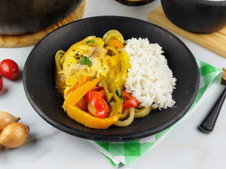 Moqueca de tilápia acompanhada por arroz branco pronta para consumo.