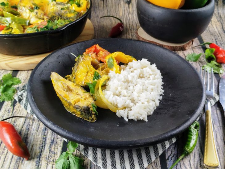 Moqueca de tilápia servida com arroz branco.