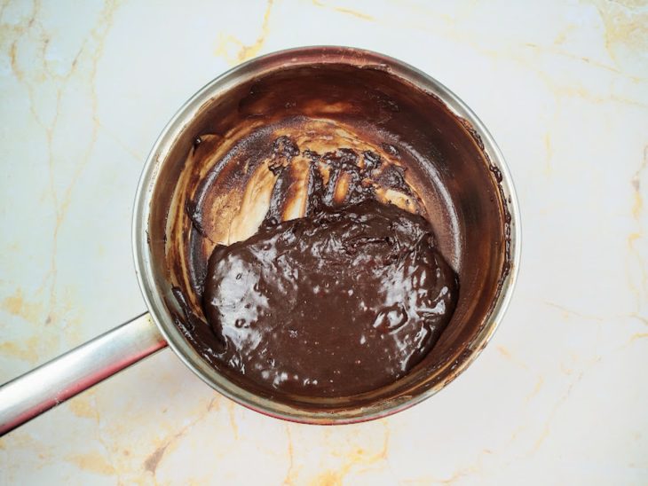 Uma panela com a mistura de leite condensado, manteiga e chocolate em pó.