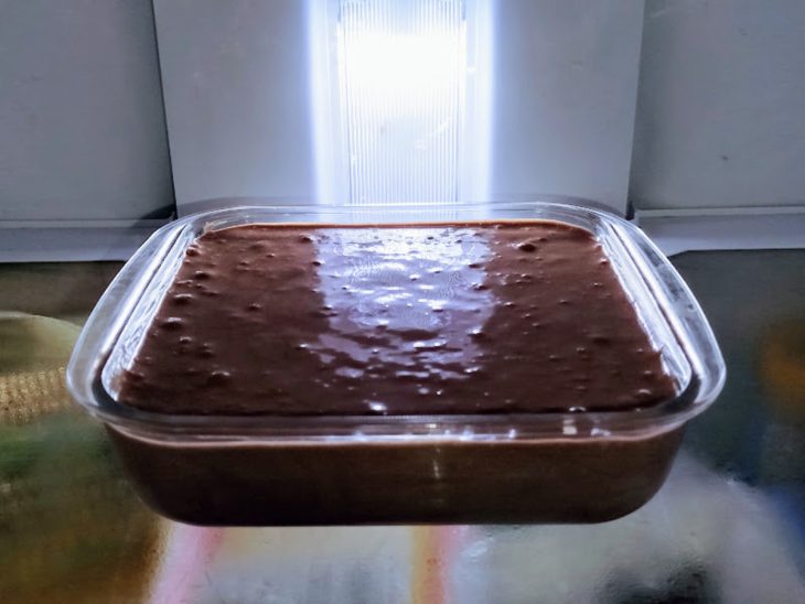 Um refratário na geladeira com mousse de chocolate em pó.