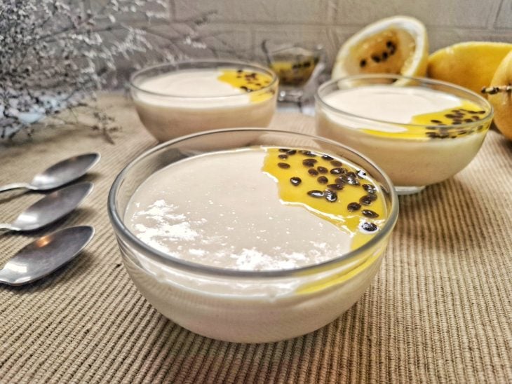 Mousse de maracujá com suco pronto para servir e decorado com polpa de maracujá.